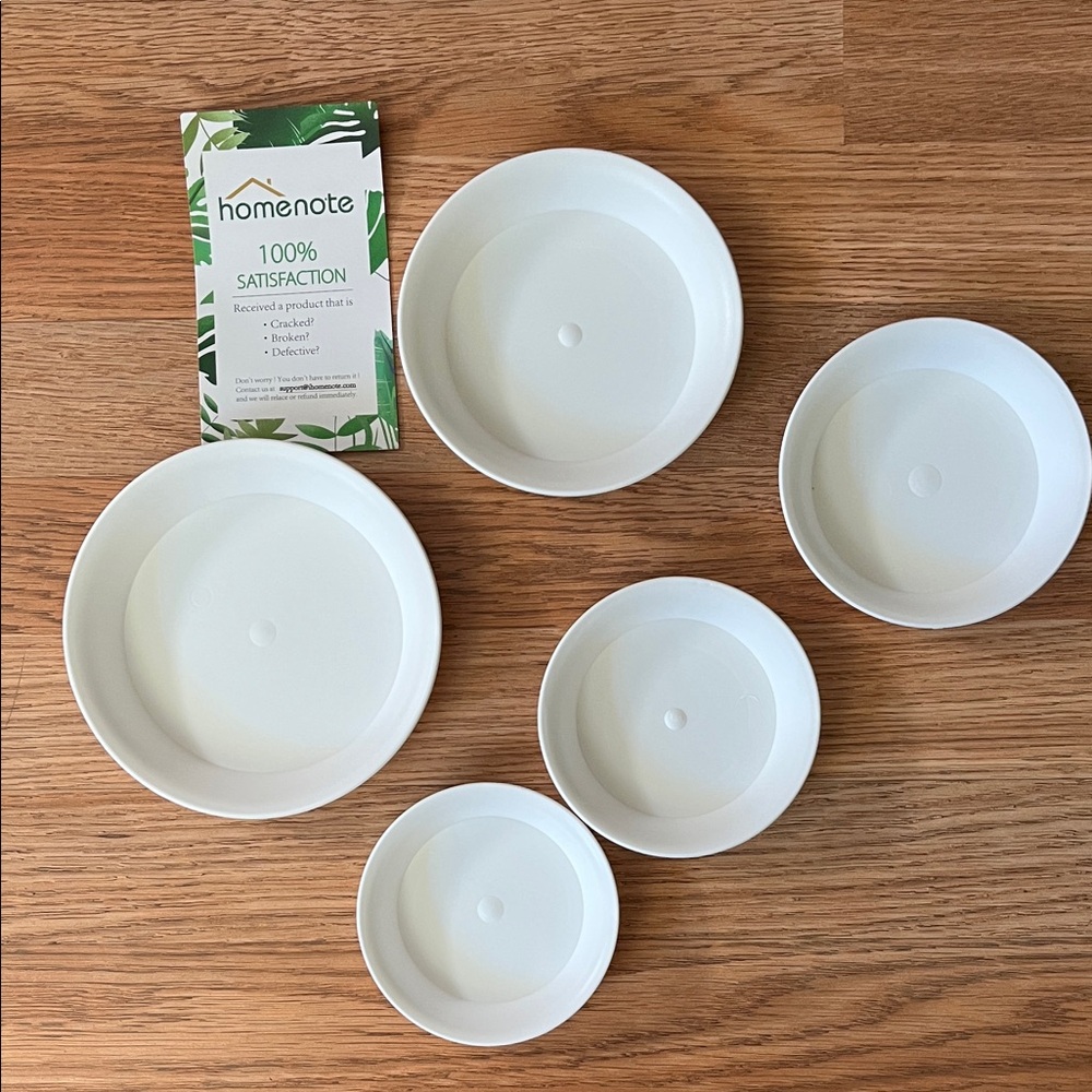 Set of white plastic potting saucers for potted plants
